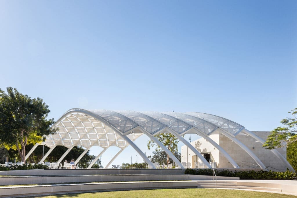 A photo showing the entirety of The Bay structure during the day with the extended grass and concrete seats in front of it.