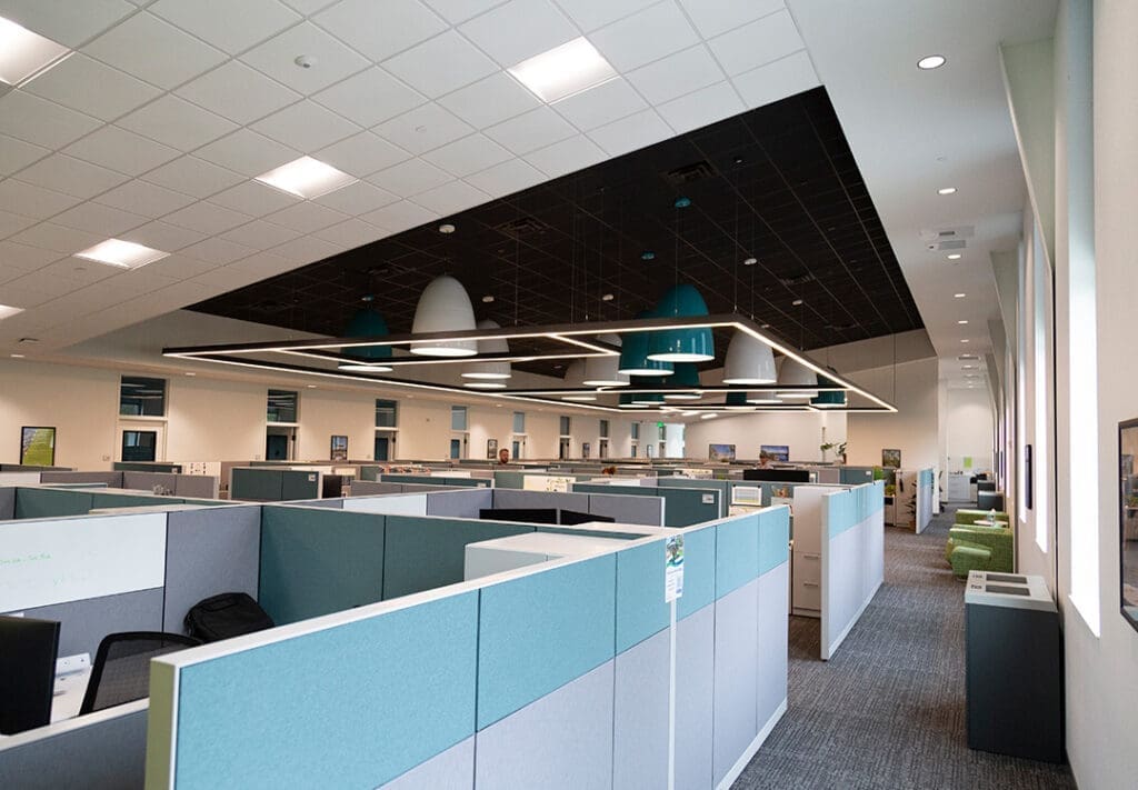 Open office workstations and suspended pendant lighting inside the new Sarasota County Parks, Recreation, and Natural Resources Administration Center.