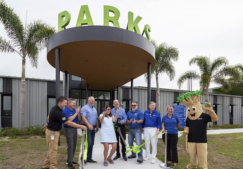 Officials cut a green ribbon beneath the entrance canopy at the grand opening of the Sarasota County Parks, Recreation, and Natural Resources Administration Center.